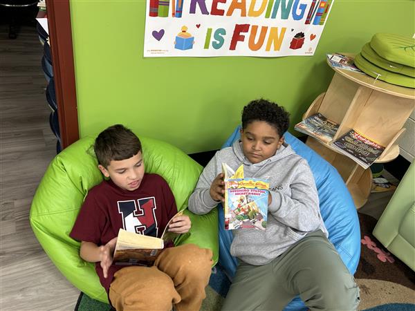 2 boys reading books on beanbags