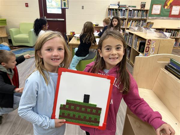 2 girls creating a design with squares