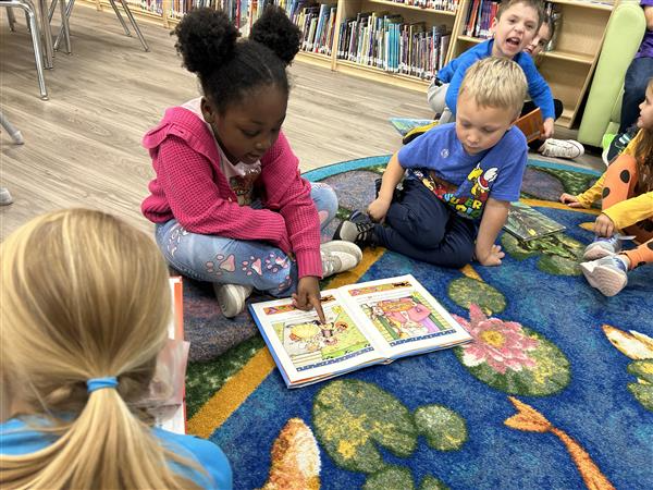 children reading a book in the library